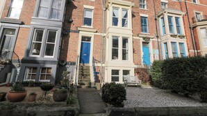 A row of terraced houses with a central staircase leading to the entrance. - Cuckoo's Nest (Whitby)