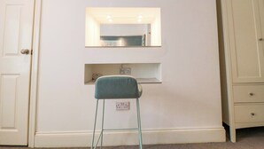 A room with a white door, a mirror above a shelf, and the word 'SEA' spelled out on the wall. - The Hideaway (Whitby)