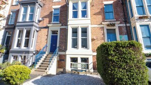 A row of terraced houses with brick facades, white window frames, and blue doors. - The Hideaway (Whitby)