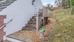 Een wit gebouw met een houten trap naar een veranda.