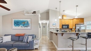 Una cocina moderna con una isla central, armarios de madera y electrodomésticos de acero inoxidable.