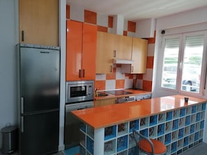 A kitchen with a refrigerator, oven, microwave, and a sink. - Hello Home Madrid (Madrid)