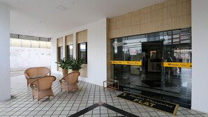 A hotel lobby with wicker chairs, a potted plant, and a tiled floor. - Studio Manaira #805 - Flat on the Beach by Carpediem (Cabedelo)