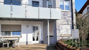 Ein zweistöckiges Haus mit Balkon, Garage und Garten.