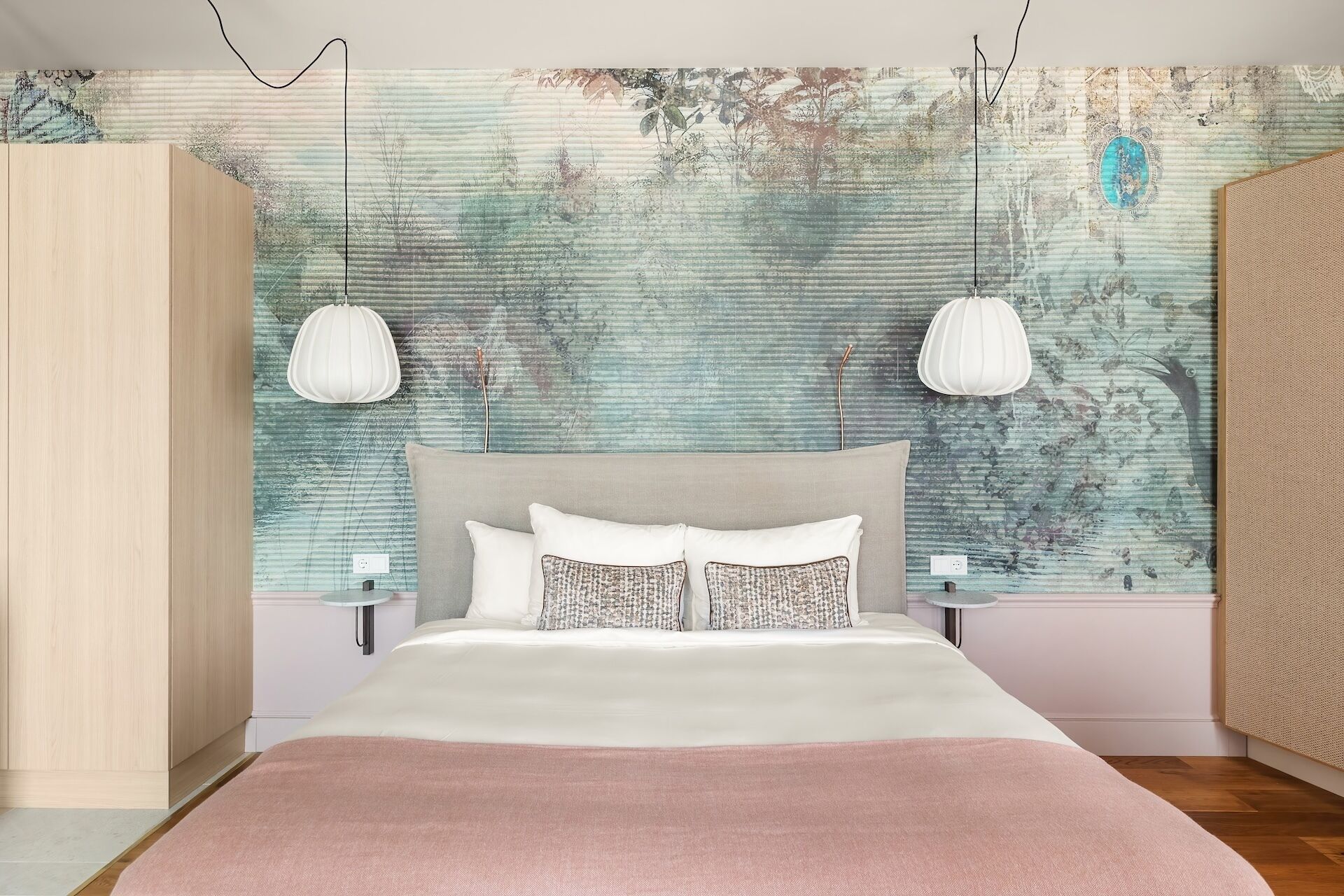 Un dormitorio con cama, dos mesitas de noche, un armario y un mural texturizado en la pared.