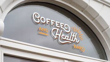 A coffee shop sign with the words "Coffee and Health Bar" in a stylized font.