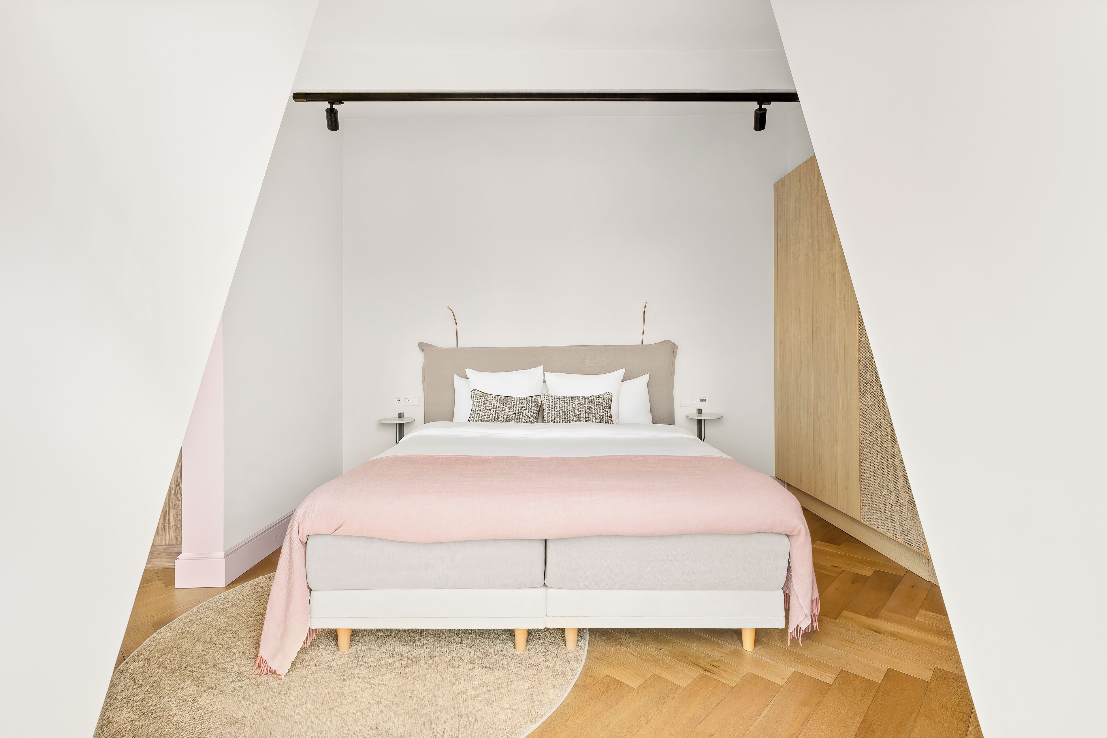 Quarto com cama, mesas de cabeceira e luminária pendente.