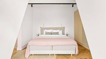 Quarto com cama, mesas de cabeceira e luminária pendente.
