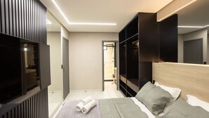 A modern bedroom with a bed, built-in wardrobe, and a walk-in closet. - Mindset #207 - Comfort and Location by Carpediem (João Pessoa)