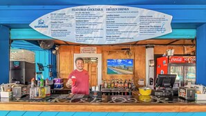 Una barra con un tablero de menú que muestra cócteles y bebidas congeladas especiales.