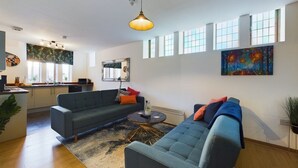 Ein modernes Wohnzimmer mit einer Couch, einem Couchtisch und Kunstwerken an den Wänden.