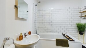 Ein modernes Badezimmer mit Waschbecken, Spiegel und Badewanne.