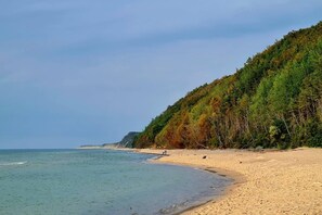 A beach with a forested hillside, clear sky, and calm sea. - Holiday home, large garden with gazebo, playground (Debina)