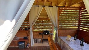 A wooden cabin with a covered porch, a table with a bench, and a grill. - Holiday home, large garden with gazebo, playground (Debina)