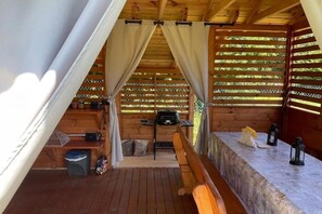 A wooden cabin with a covered porch, a table with a bench, and a grill. - Holiday home, large garden with gazebo, playground (Debina)