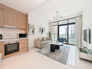 Eine moderne Wohnung mit Küche, Wohnbereich und großen Fenstern mit Blick auf die Stadt.