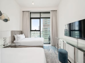A modern hotel room with two beds, a large window with a city view, a flat-screen TV, and a glass desk. - Beachfront Living with Marina Skyline Views (Dubai)