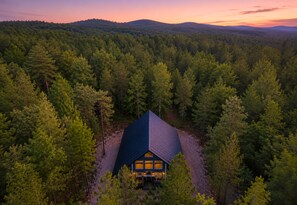 A cabin surrounded by dense forest with a clear view of the surrounding landscape. - Hot Tub | Fire Pit | Foosball | Arcade Machine (Broken Bow)