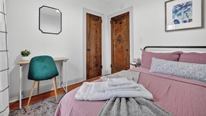 A bedroom with a bed, a desk, a chair, and a mirror. - 1br apt - heart of Uptown Maumee w/ Fiber WiFi. #3 (Maumee)