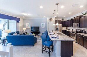 A modern apartment with a living room, dining area, and kitchen. - Themed 5BR Home Near Disney (Kissimmee)