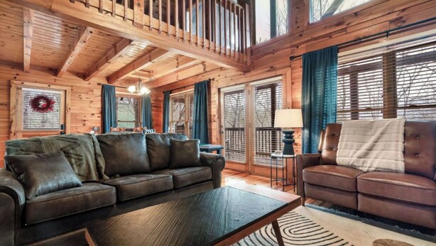 A cozy cabin interior with a wooden ceiling, a dark leather sofa, a matching armchair, and a small table. - *Relaxing  2BD Cabin Near TOWN | Hot Tub + VIEWS* (Pigeon Forge)