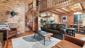 A cozy log cabin interior with a living room, kitchen, and dining area. - *Relaxing  2BD Cabin Near TOWN | Hot Tub + VIEWS* (Pigeon Forge)