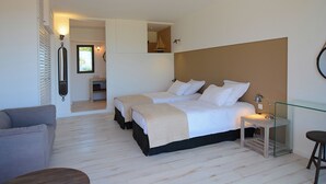 A bedroom with two beds, a small table, a chair, and a sofa. - Architect-designed 4-bedroom villa with pool in palombaggia with sea view (Porto-Vecchio)