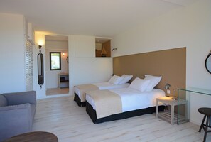 A bedroom with two beds, a small table, a chair, and a sofa. - Architect-designed 4-bedroom villa with pool in palombaggia with sea view (Porto-Vecchio)