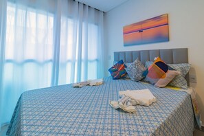 A hotel room with a large bed, a headboard, and a painting of a sunset on the wall. - Villa Del Porto #04 - W/ Private Pool by Carpediem (Ipojuca)