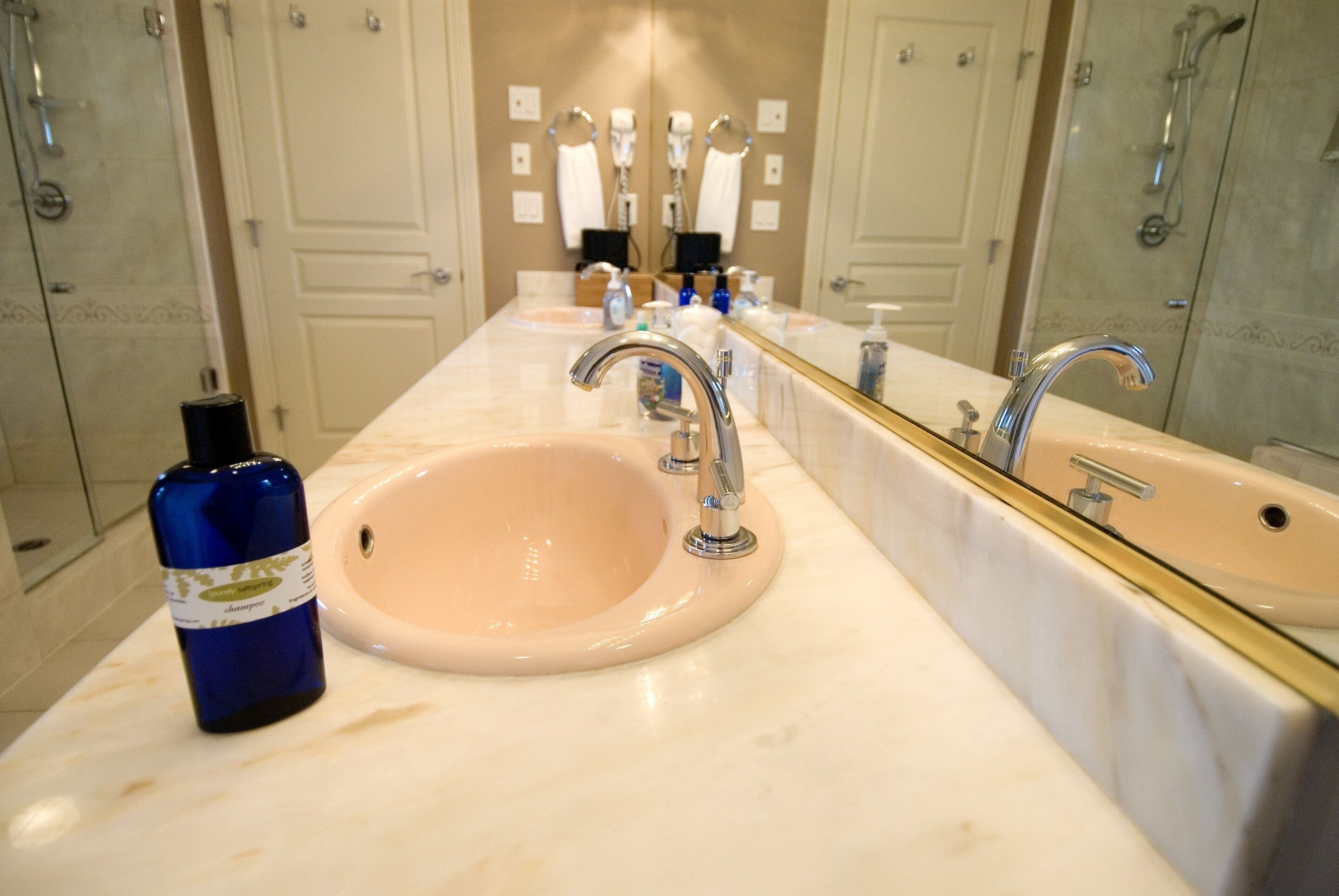 Une salle de bain avec un grand lavabo, un miroir et un espace douche.
