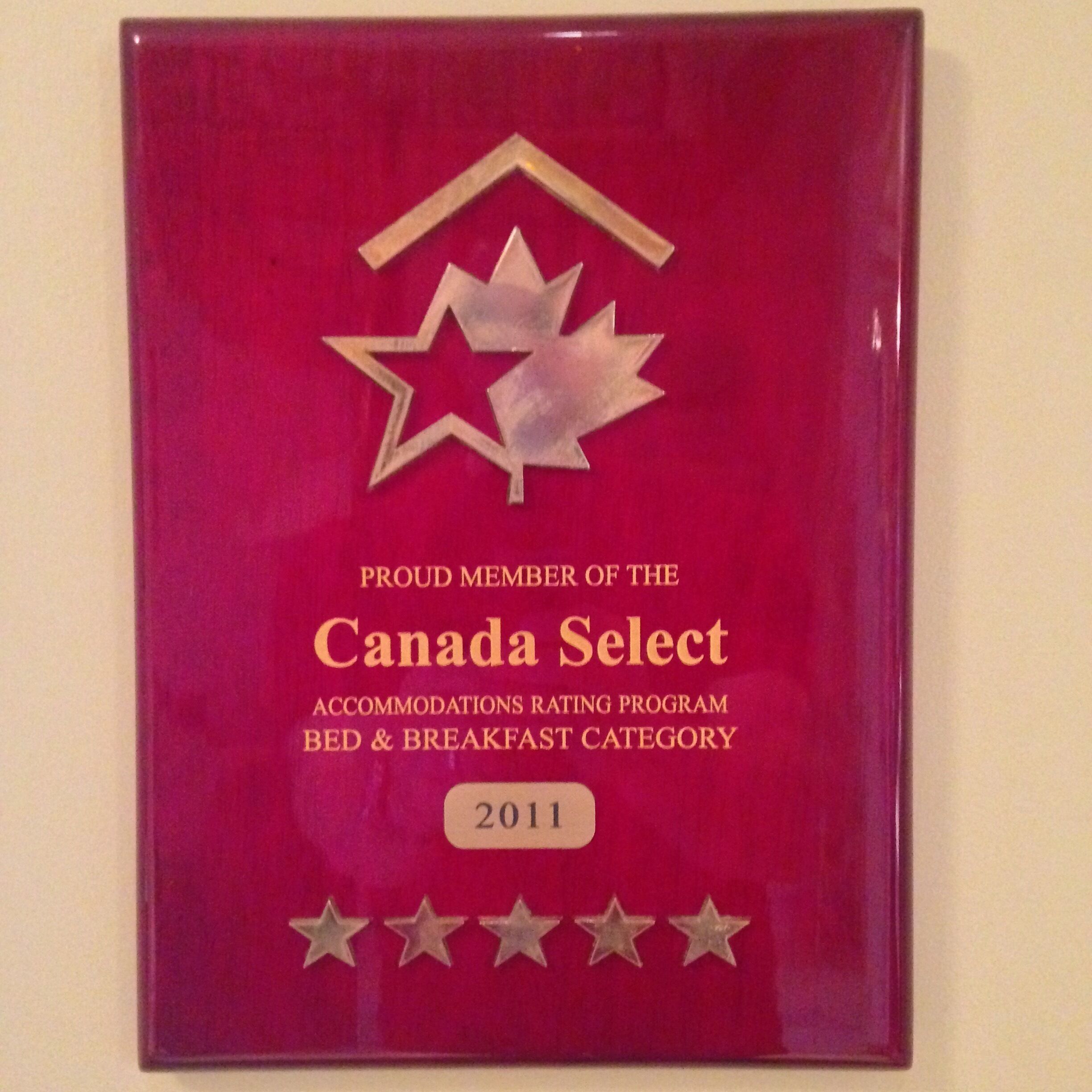 Eine rote Plakette mit dem Text "Stolz Mitglied des Canada Select Accommodations Rating Program, Kategorie Bed & Breakfast 2011" und fünf Sternen darunter.