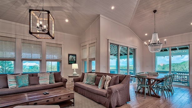 A spacious living room with a large sofa, a dining table with chairs, and a chandelier. - 🏖️Pet Friendly | 6 Bikes | Walk to Beach | Sea Glass on 30A🏖️ (Santa Rosa Beach)