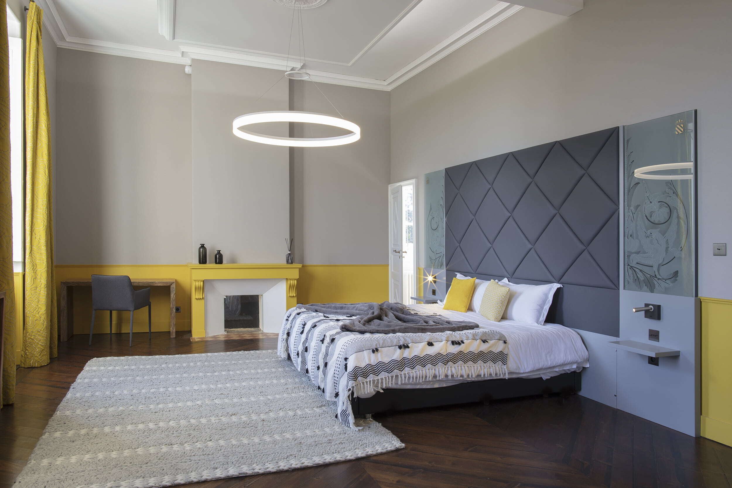 Une chambre à coucher avec un lit, un bureau et une cheminée.