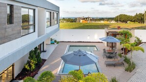 Un bâtiment moderne doté d’une piscine, d’un espace extérieur aménagé et offrant une vue sur le paysage environnant.