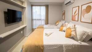 A hotel room with two beds, a flat-screen TV, air conditioning, and artwork on the walls. - Enseada de Coqueirinho #201 - Apt by Carpediem (João Pessoa)