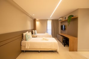 Ein Hotelzimmer mit zwei Betten, einer Holzbank, einem Fernseher und einer Pflanze.