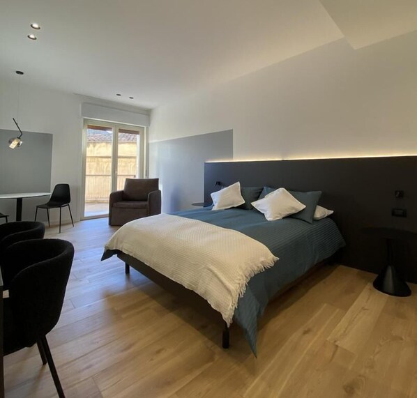 Una camera da letto moderna con un letto grande, una scrivania e una sedia.