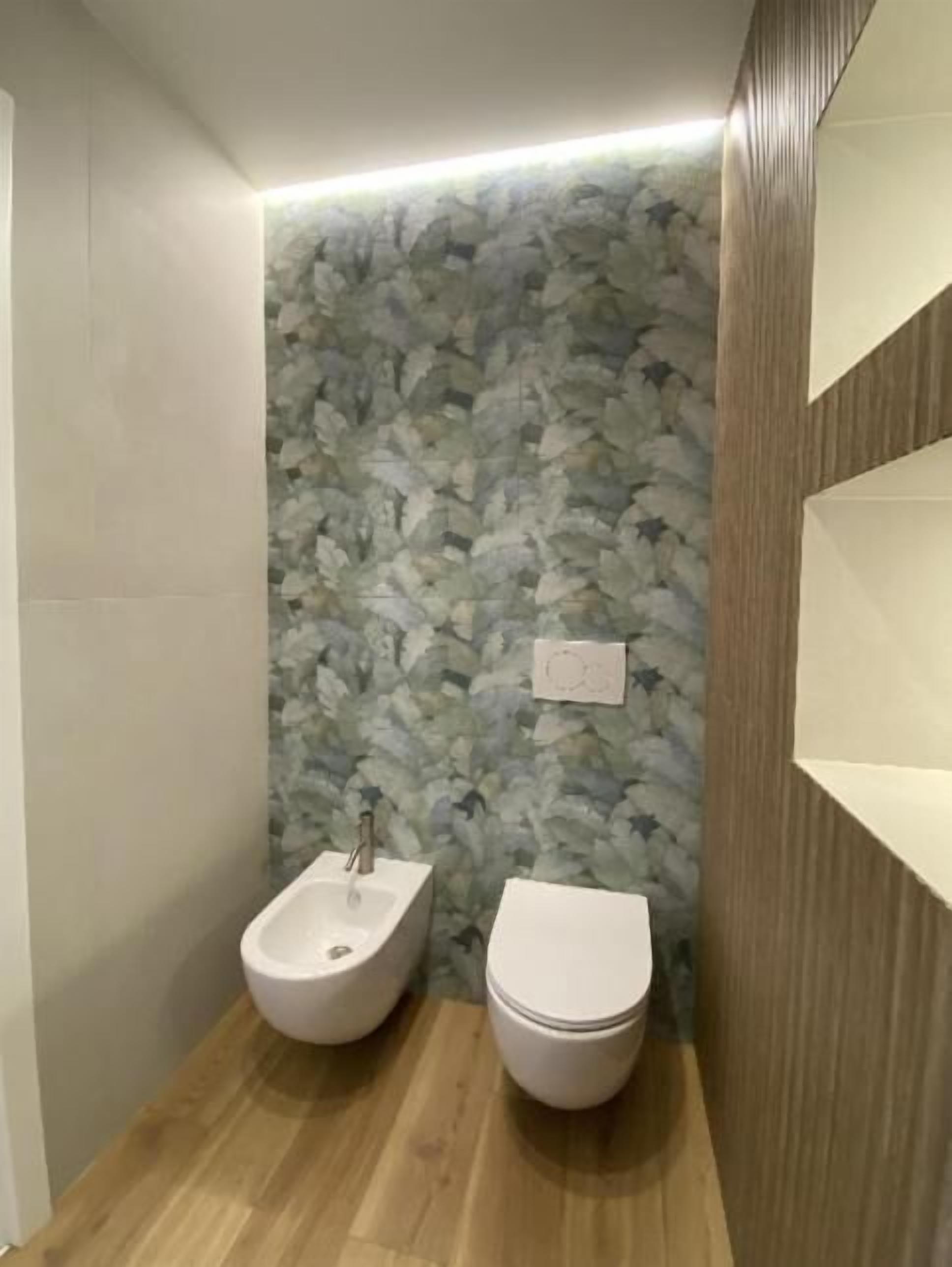 A bathroom with a wooden floor, a wall-mounted sink, and a toilet.