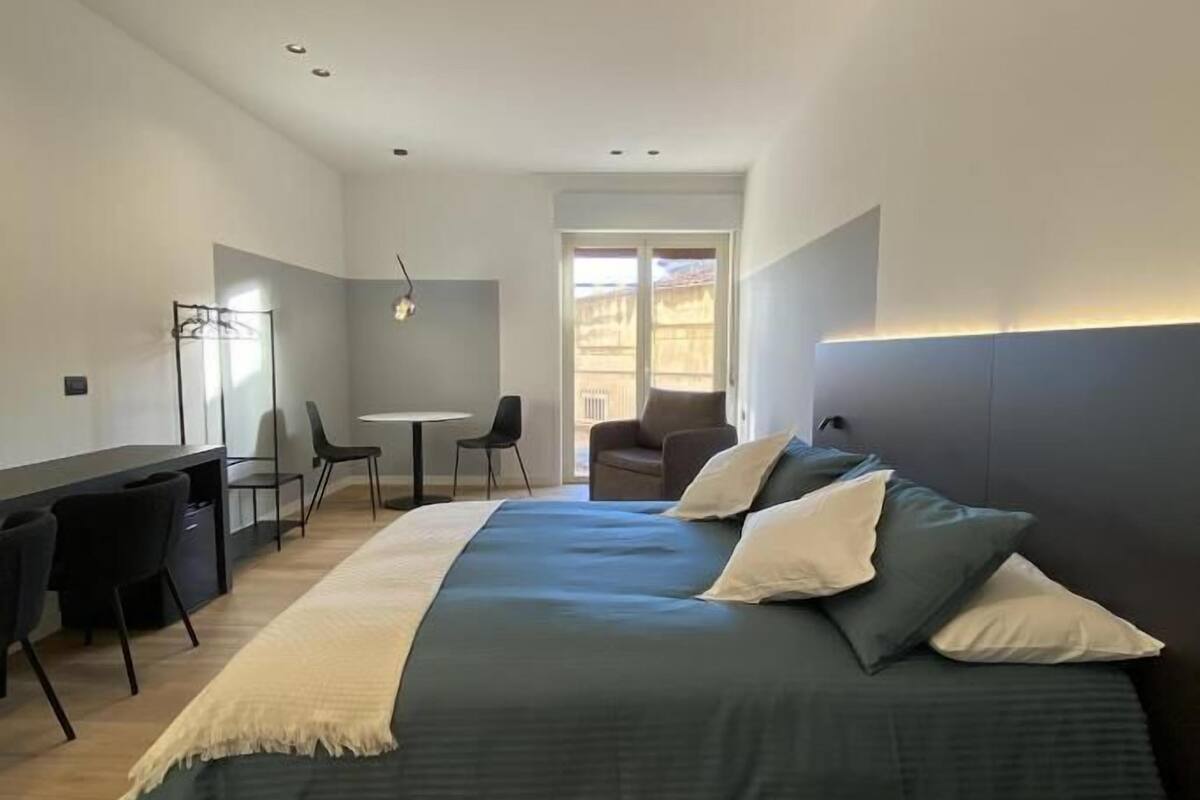 Une chambre moderne avec un grand lit, un bureau et une chaise.