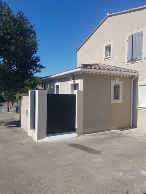 A building with a gated entrance, a small attached structure, and a tiled roof. - Charming Villa in St Rémy de Provence with Pool (Saint-Rémy-de-Provence)