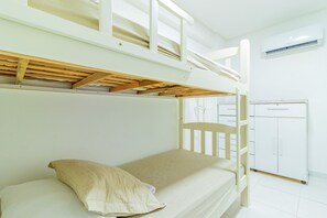 A bunk bed room with a white ceiling, a white wardrobe, and a white air conditioning unit. - Eco Life #105 - Apt With Balcony by Carpediem (Ipojuca)