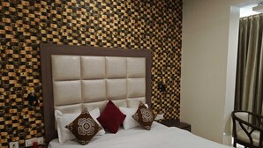 Un lit bien fait, avec une tête de lit, un mur au motif de briques et une chaise.
