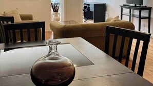 Una sala de estar moderna con una mesa de comedor, dos sofás, un televisor y un cuadro en la pared.