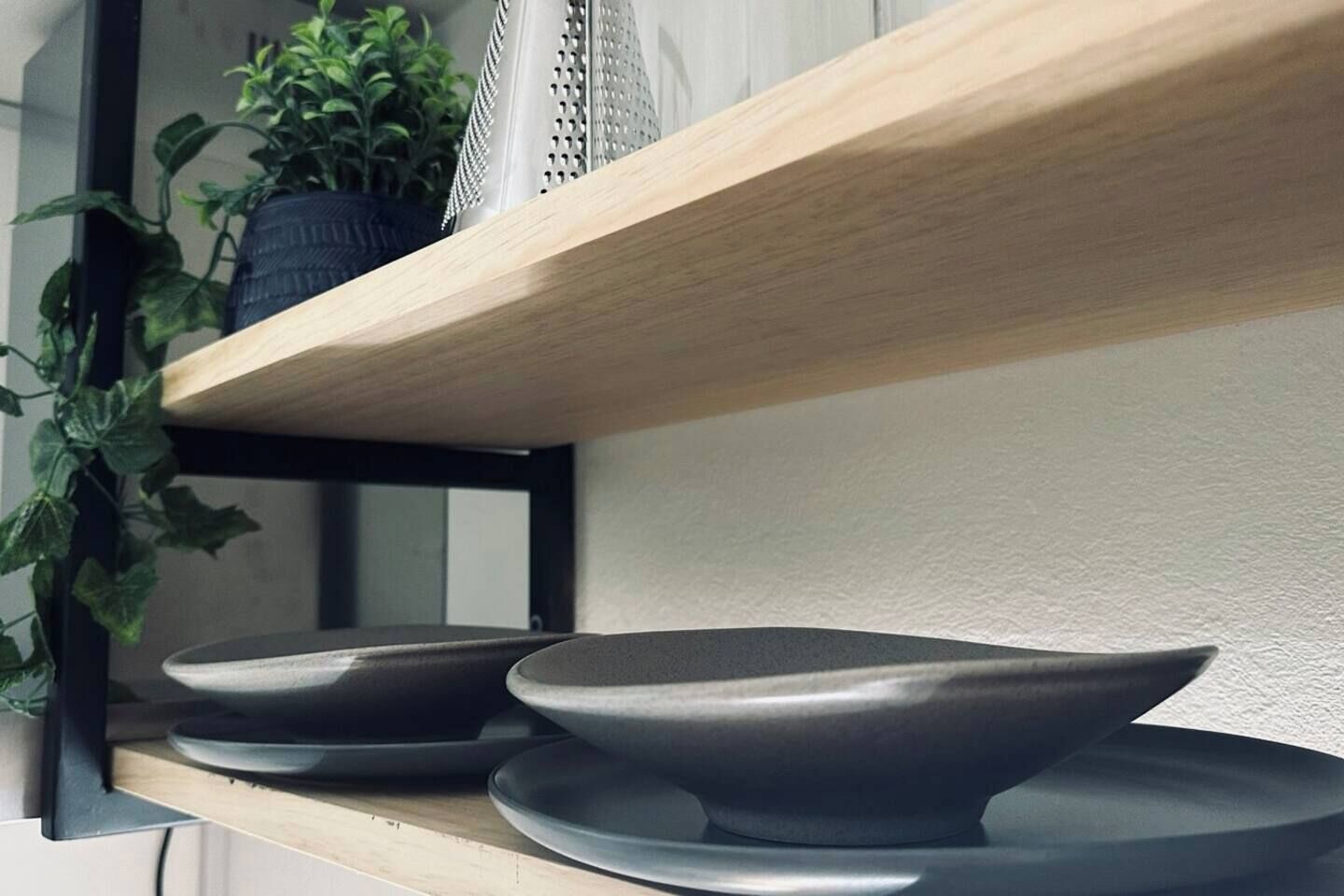 Une étagère avec deux bols et une plante en pot.
