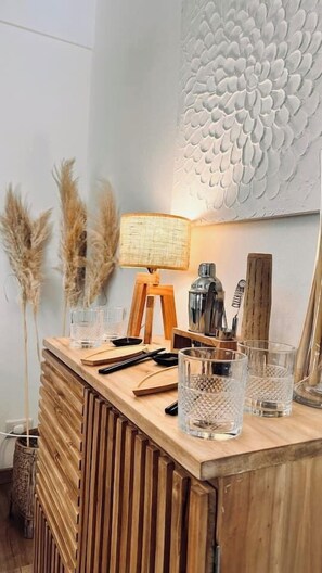 Een bar met houten toonbank, een textuurwand, een lamp en decoratief riet.