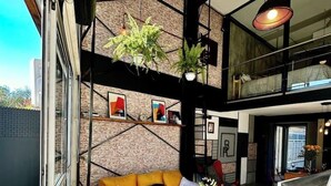 Un interno moderno con un divano giallo, una scala e un'area pranzo.