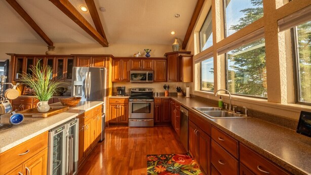 A spacious kitchen with wooden cabinets, stainless steel appliances, and a large window providing natural light. - Triangle Ranch - Private West Texas Retreat (Alpine)
