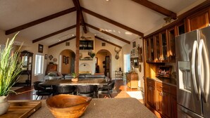 A spacious kitchen with high ceilings, wooden beams, and a large stainless steel refrigerator. - Triangle Ranch - Private West Texas Retreat (Alpine)