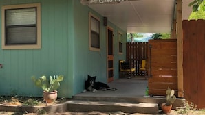 Ein kleines Gebäude mit einem Schild, auf dem "La Cajita" steht, und einer Katze, die auf den Stufen sitzt.