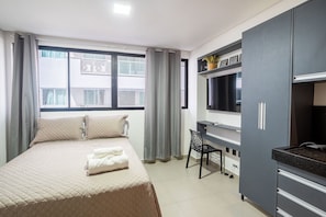 A bedroom with a bed, a desk, and a wardrobe. - Get One #209 - Studio in Jampa by Carpediem (João Pessoa)